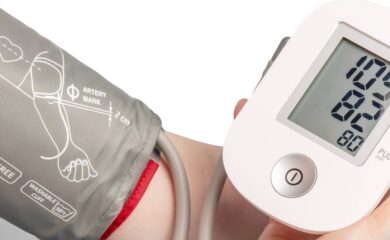 A close up of a person's arm wearing a blood pressure cuff as they test their blood pressure
